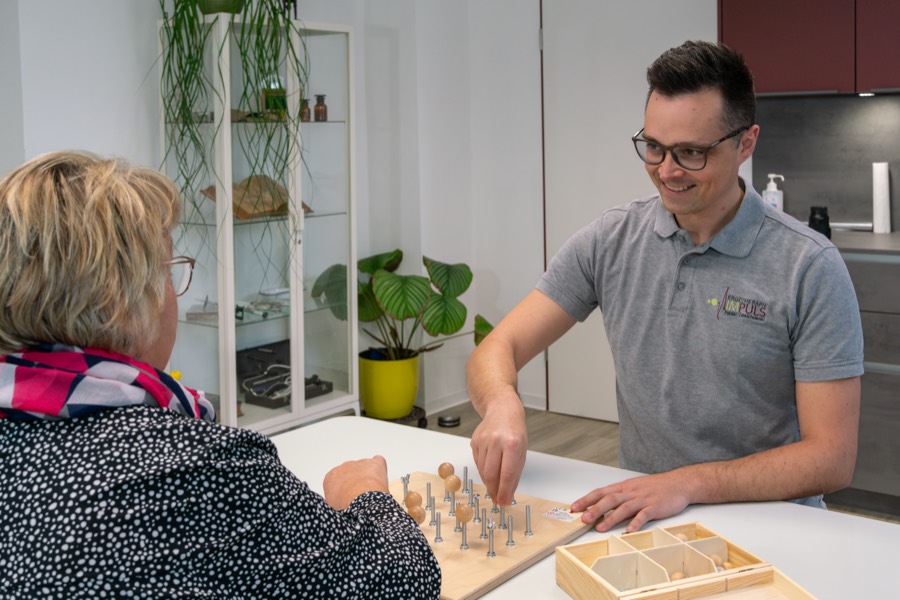 Mitarbeiter im Gespräch mit einer Klientin am Tisch